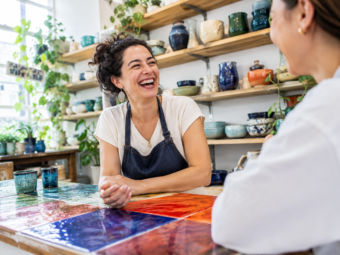 Céramiste échangeant avec une cliente dans sa boutique